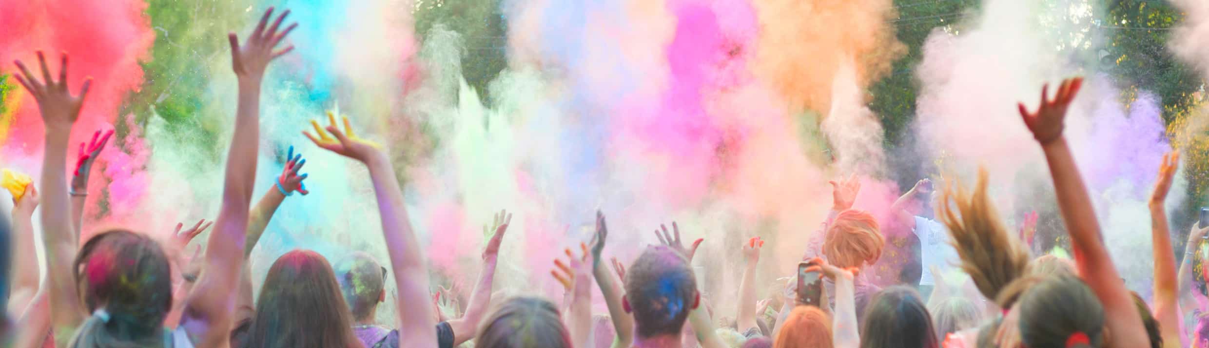 Les festivaliers lancent de la poudre colorée dans les airs lors d'un festival.