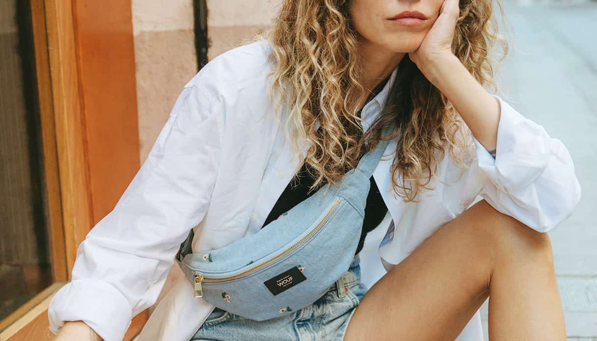 Un mannequin féminin est assis dans la rue avec une banane en denim sur son épaule.