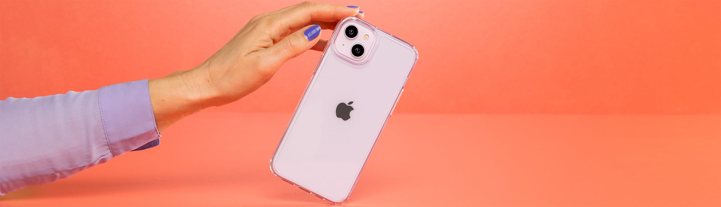 Une main de femme tenant un iPhone, l'arri&egrave;re-plan est orange.
