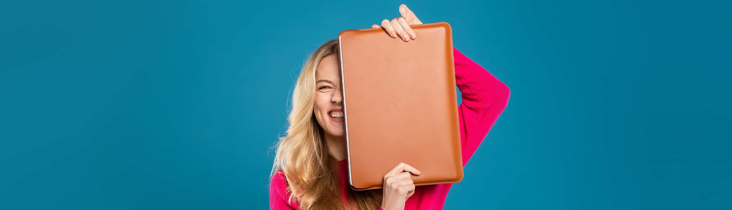 Une femme, souriante avec une pochette d'ordinateur portable devant elle, contenant un ordinateur protégé.