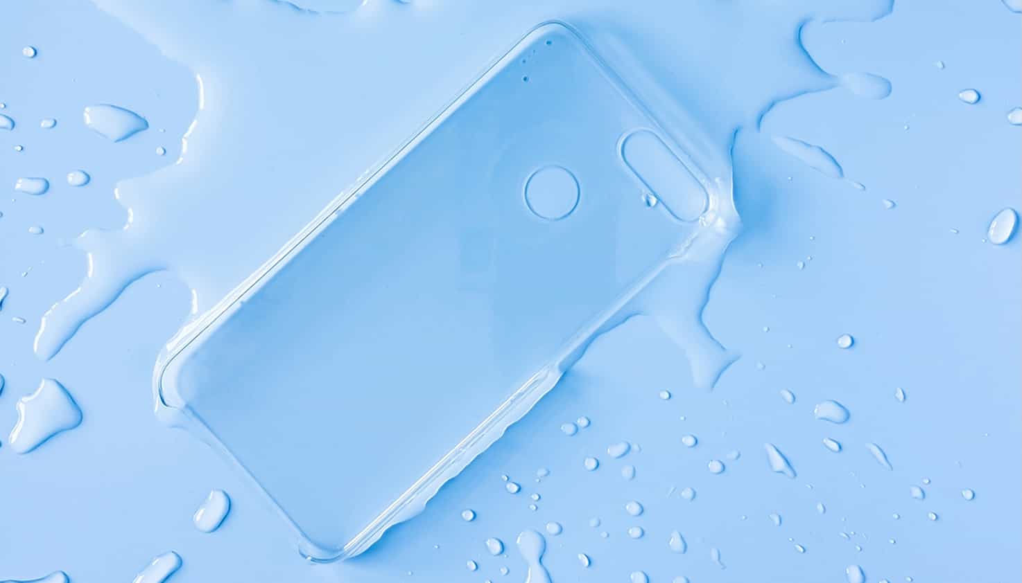 Une coque de t&eacute;l&eacute;phone transparente est pos&eacute;e dans une flaque d'eau avec des &eacute;claboussures autour.