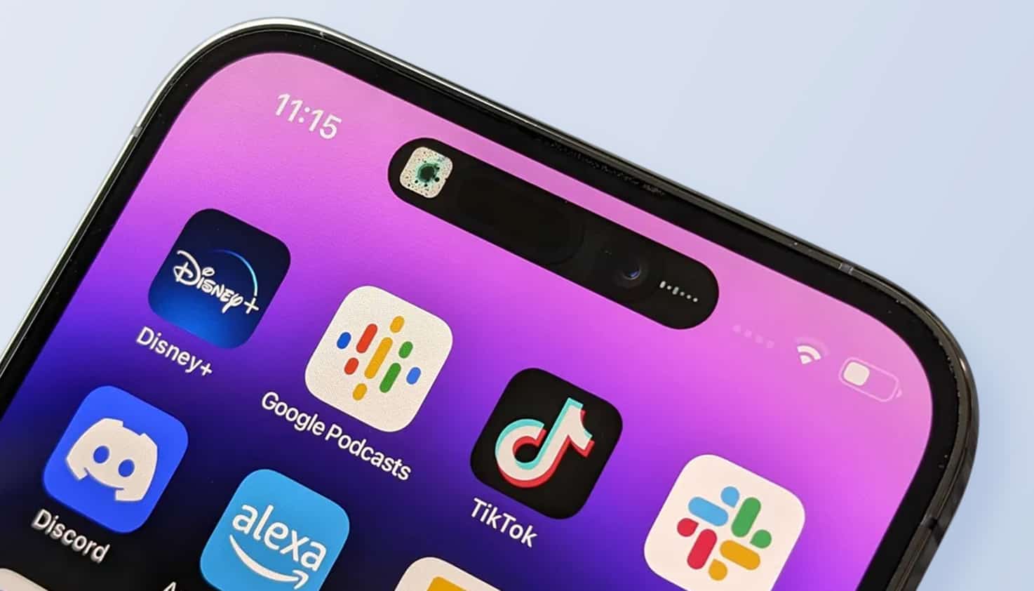 Un iPhone est visible avec un zoom sur le haut de l'écran, où l'on voit les capteurs Face ID.