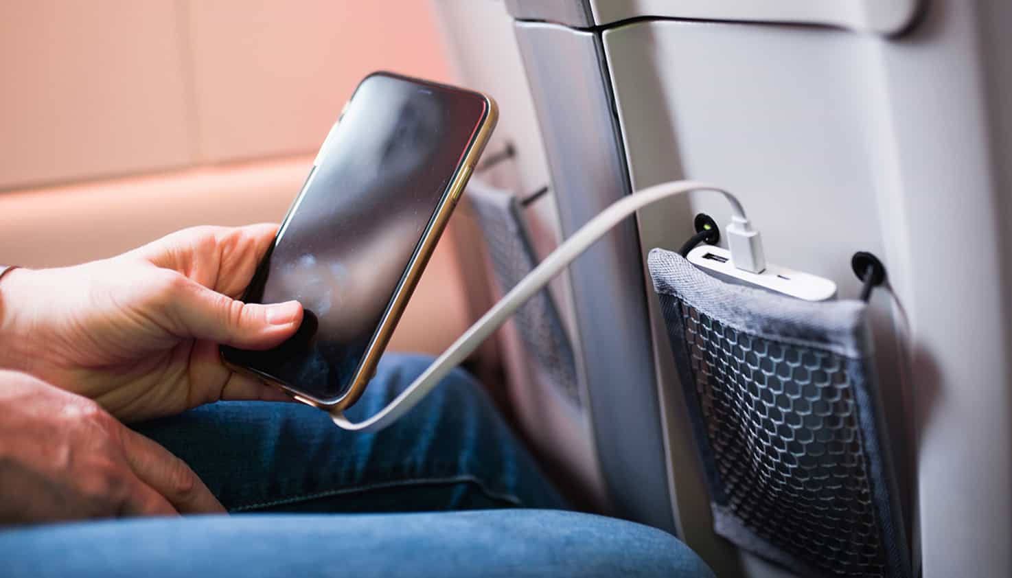 Le téléphone est dans la main du passager et sa batterie externe est dans la poche du siège devant elle.