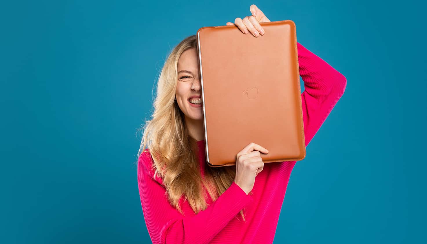 Une femme, souriante avec une pochette d'ordinateur portable devant elle, contenant un ordinateur protégé.
