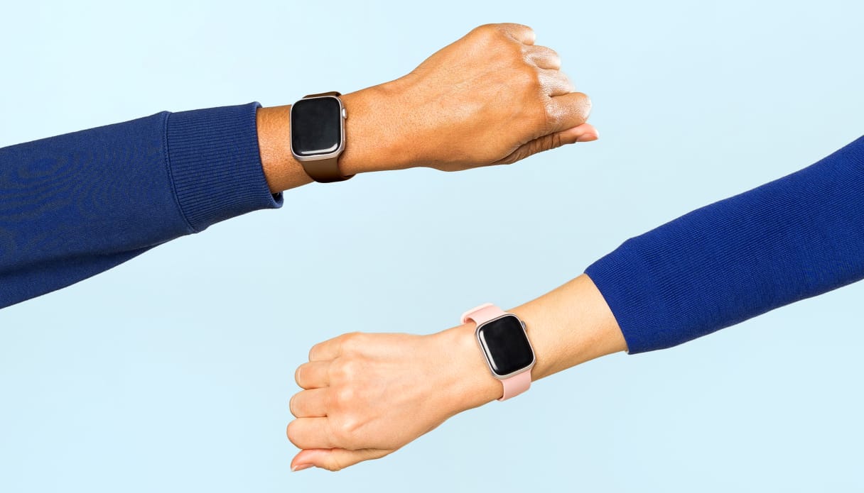 Deux avant-bras apparaissent de chaque c&ocirc;t&eacute;, tous deux avec une smartwatch au poignet, un pull bleu et un fond bleu clair.