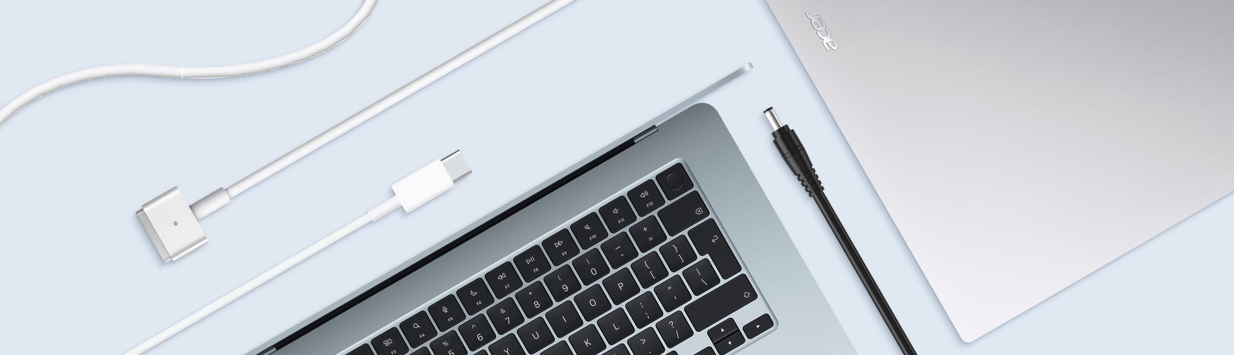 Un MacBook d'Apple et un ordinateur portable Acer entourés de différents types de chargeurs.