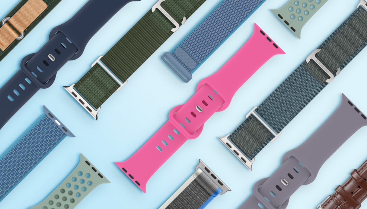 Une collection de bracelets de montre connect&eacute;e en diff&eacute;rents mat&eacute;riaux et coloris, dispos&eacute;e sur un fond bleu clair. 