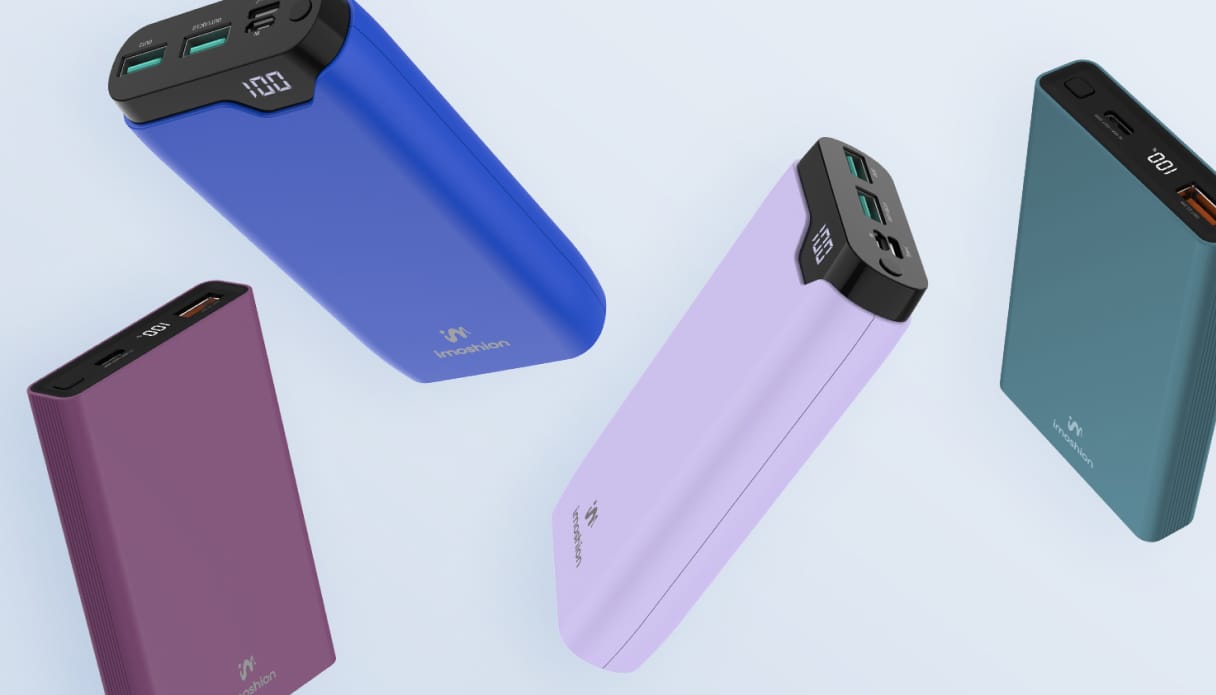 Quatre batteries externes colorées flottent sur un fond bleu clair.