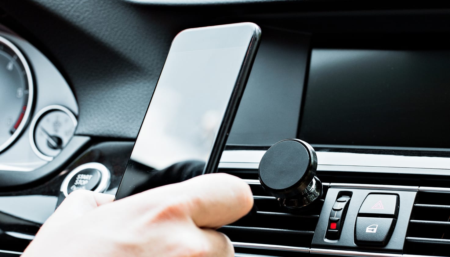 Quelqu'un dans la voiture tient le t&eacute;l&eacute;phone avec des supports. 