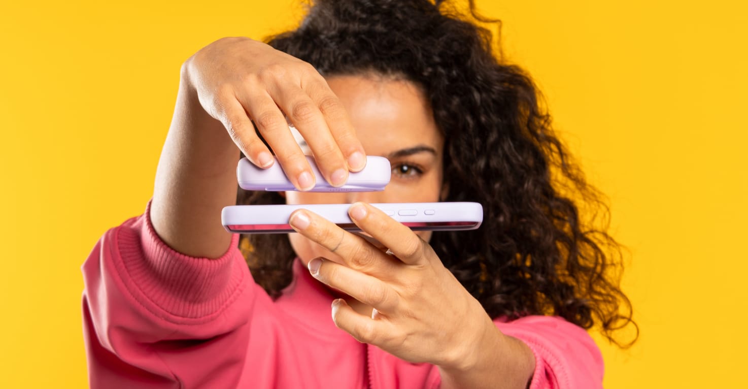 Une femme connecte une batterie externe &agrave; son t&eacute;l&eacute;phone &agrave; l'aide de MagSafe.