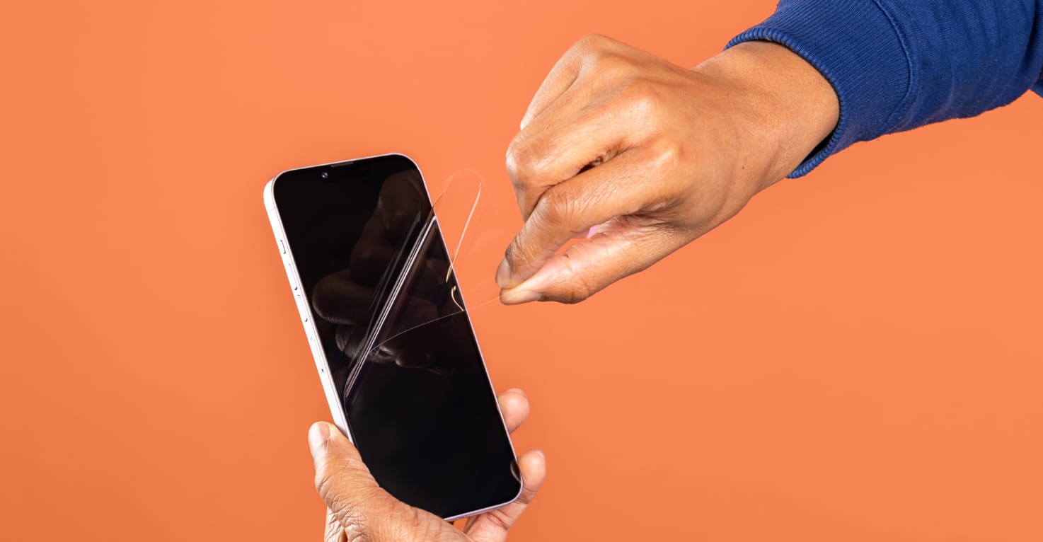 Vous voyez une main retirer un protecteur d'écran d'un smartphone.