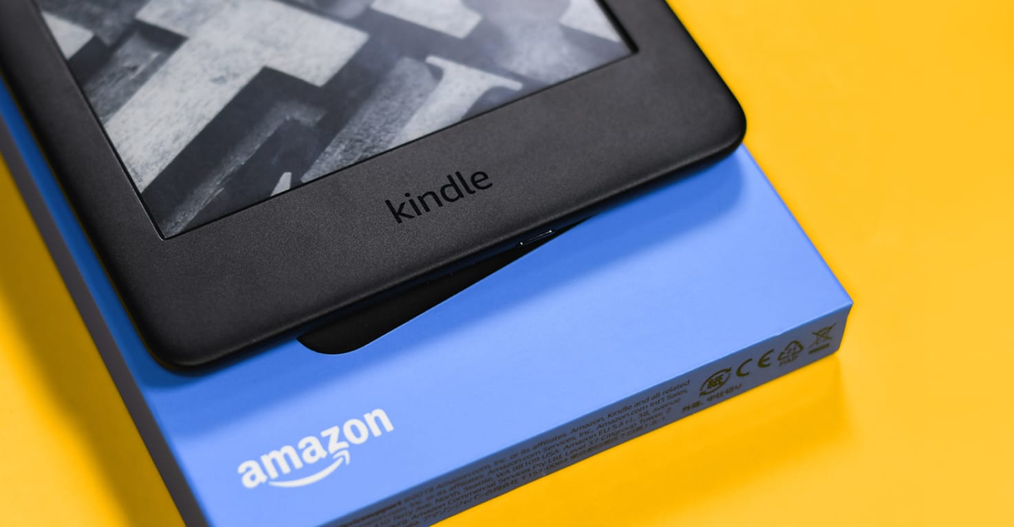 Un Amazon Kindle et son emballage sur fond jaune.
