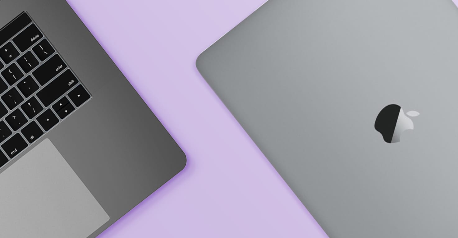 Deux ordinateurs portables Apple Macbook sur un fond violet.