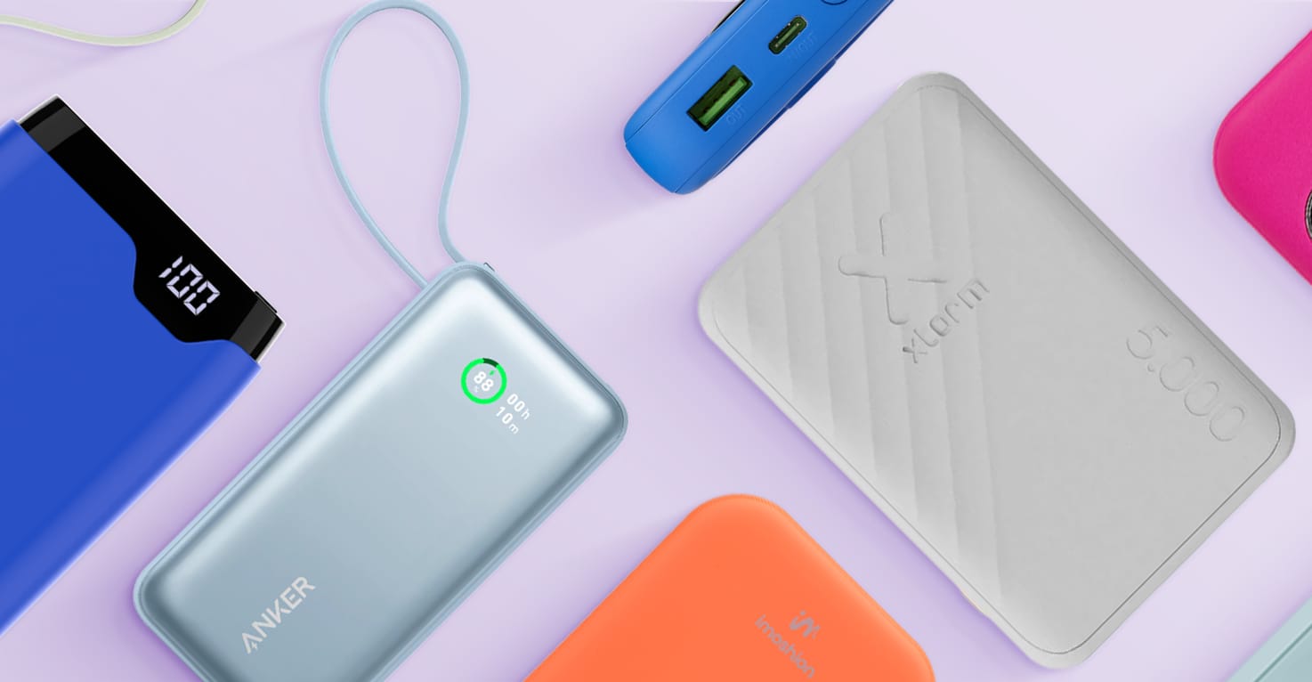 Un aperçu des différentes marques, tailles, couleurs et types de batteries externes, certaines posées à plat, d’autres sur le côté. Notamment des batteries externes Anker, Xtorm et imoshion, sur un fond violet clair.
