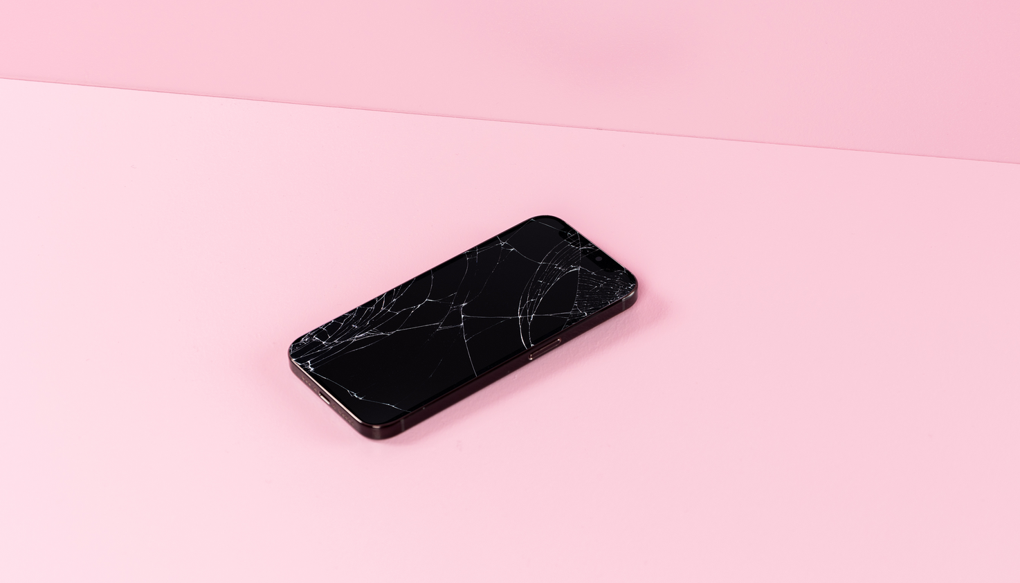 Un téléphone avec un protecteur d'écran fissuré.