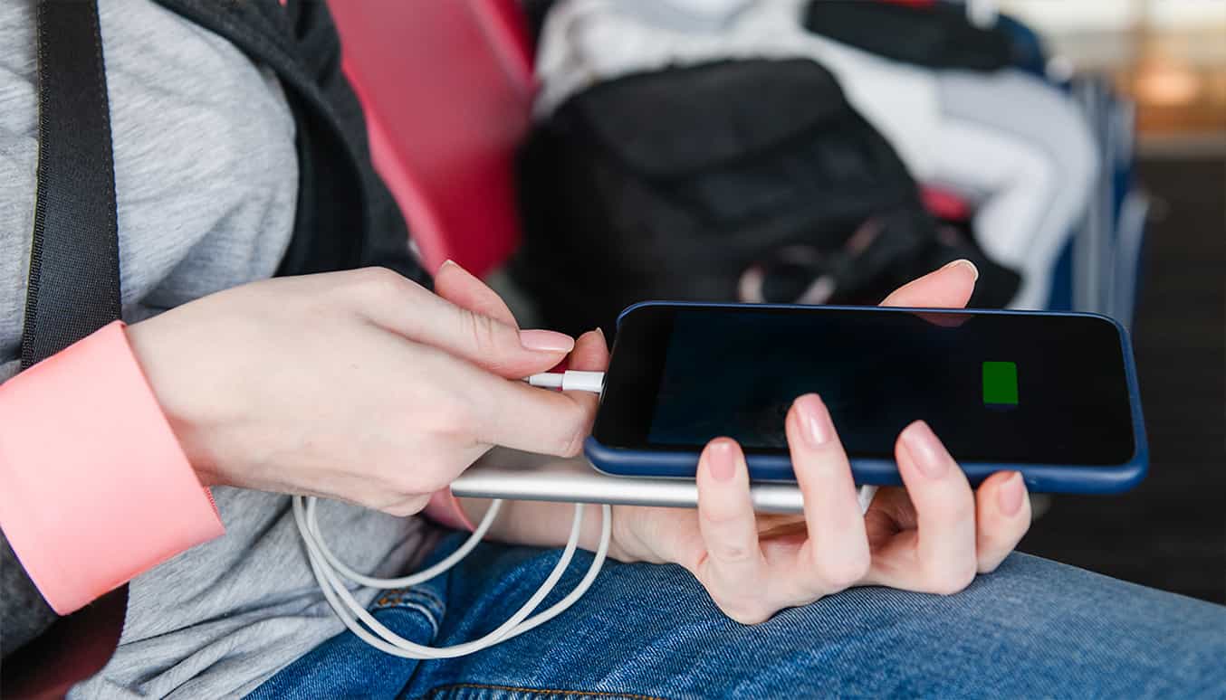 Un fond orange vif avec une batterie externe vert éclatant assortie à un téléphone.