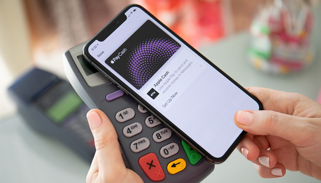 L'iPhone est placé sur le terminal de paiement pour utiliser Apple Pay.